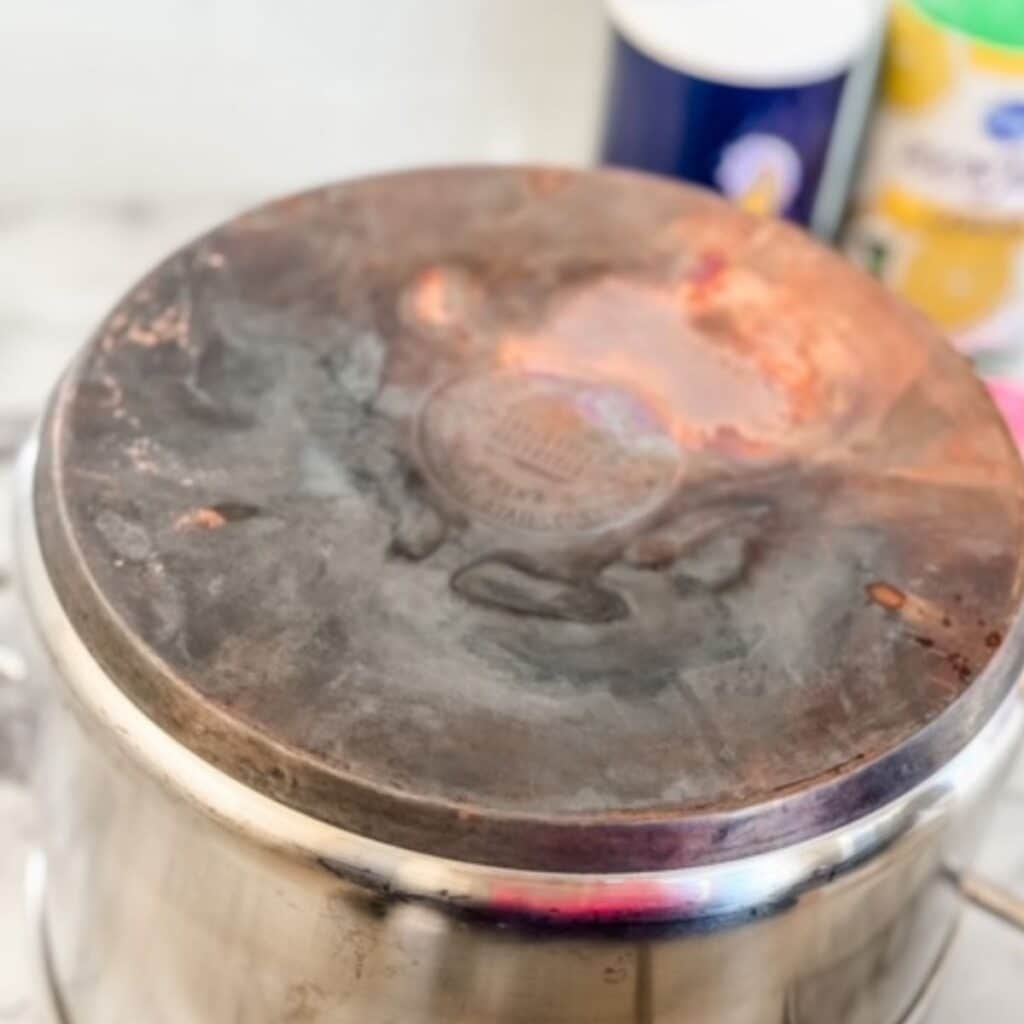 dirty copper pot with salt and lemon juice in background