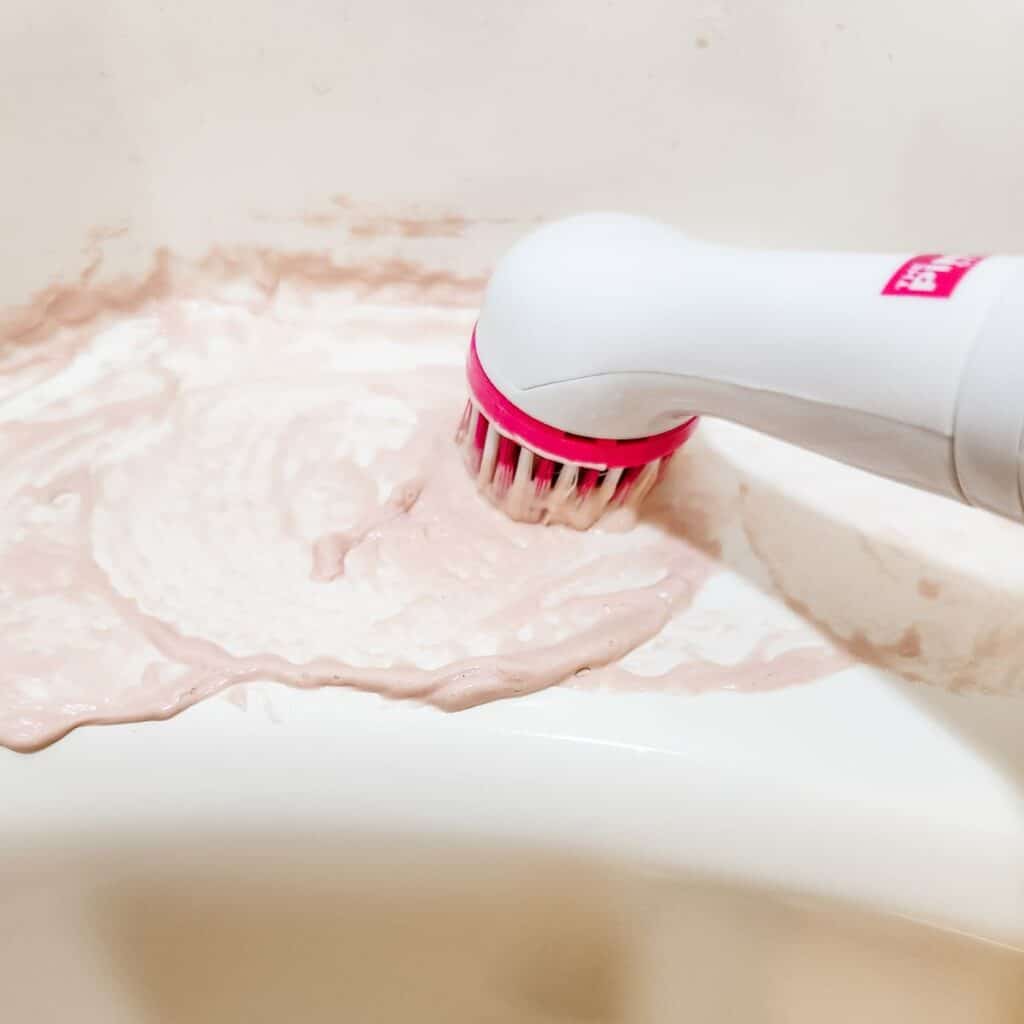 scrubbing at rust stains in bathtub