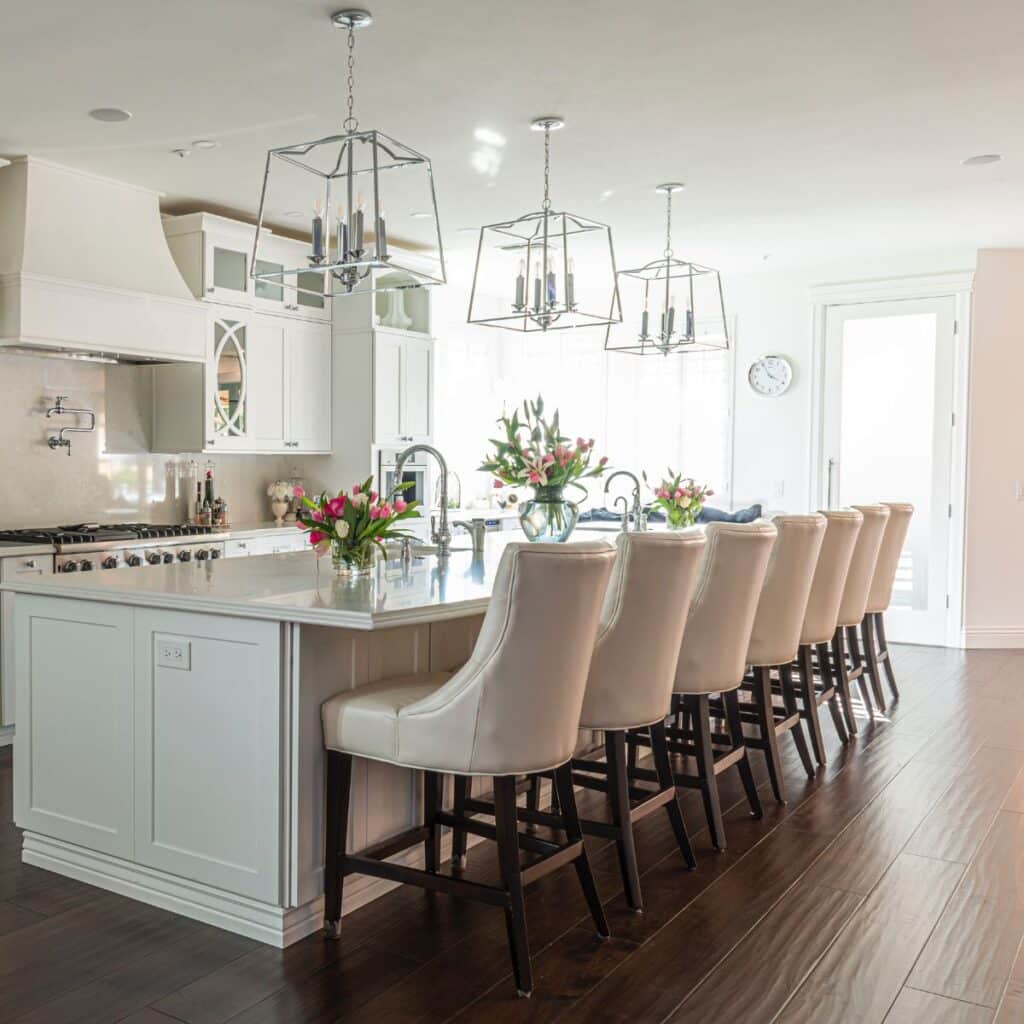 a large clean kitchen with flowers on the counter.